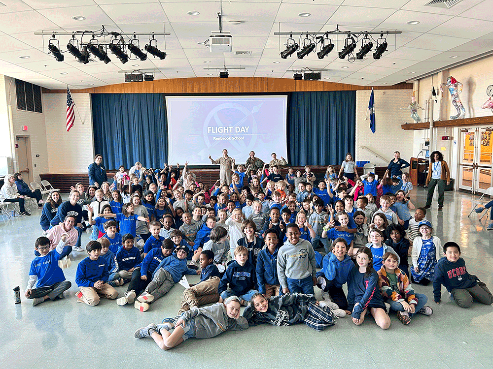 Large group of Lower School students with three Army pilots at Flight Day assembly