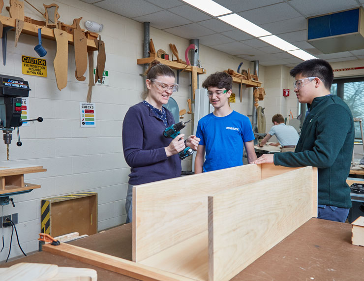 students learning to build and use tools in woodshop