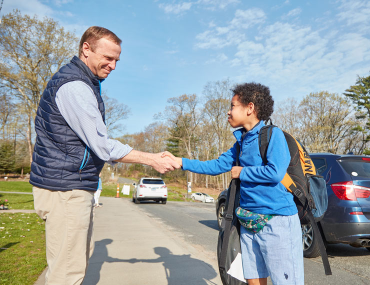 Student shaking hands with Head of Upper School at morning arrival