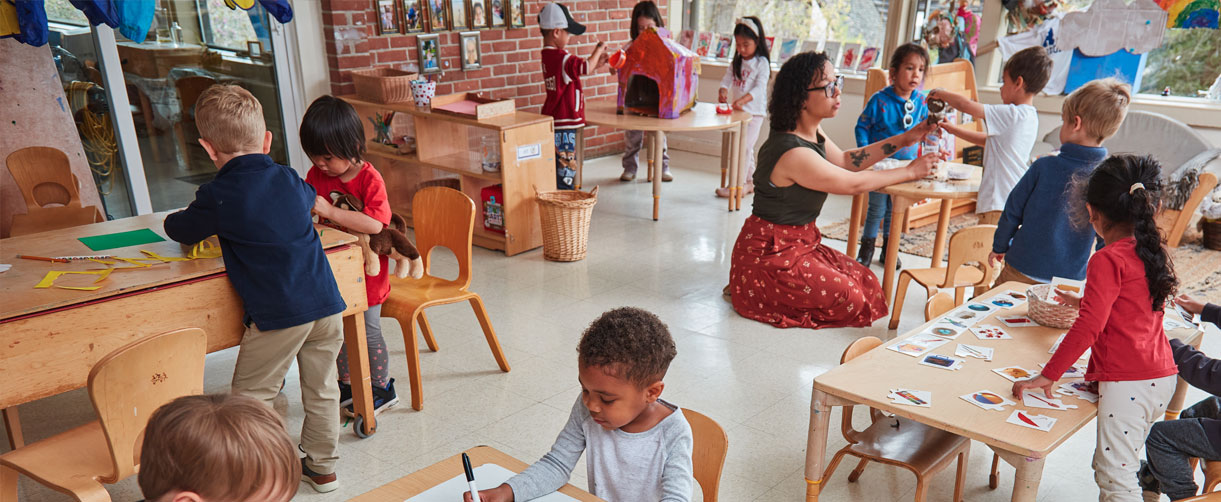 Preschoolers engaged in a variety of learning activities at tables