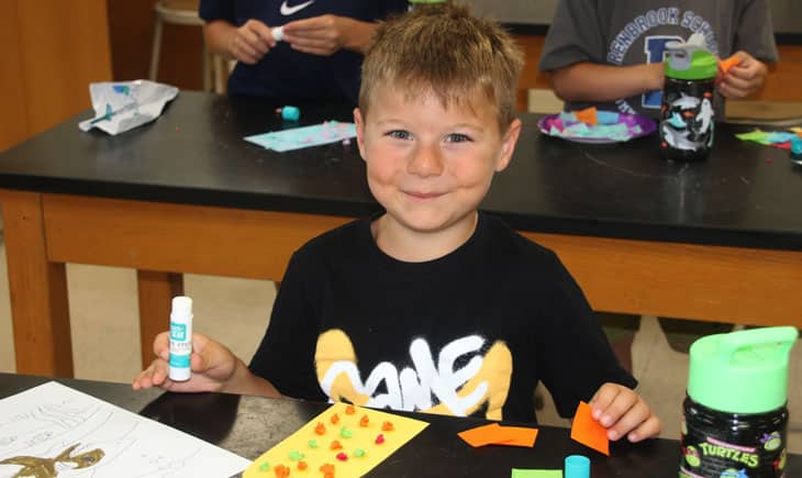 Young blond boy smiling at Arts & Crafts