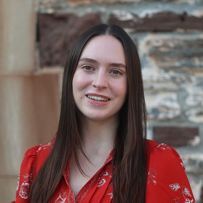 Kindergarten teacher with long brown hair wearing a red dress