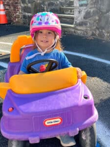 Preschool girl in Little Tikes Car outside