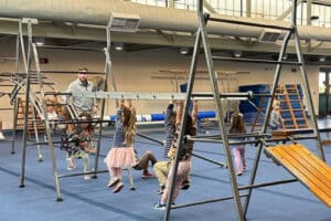 preschool children on climbing apparatus in PE class