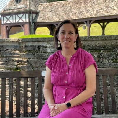 female teacher sitting on bench in pink dress