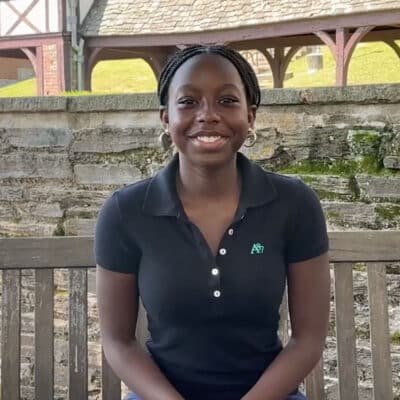 female black Grade 8 student smiling sitting on bench